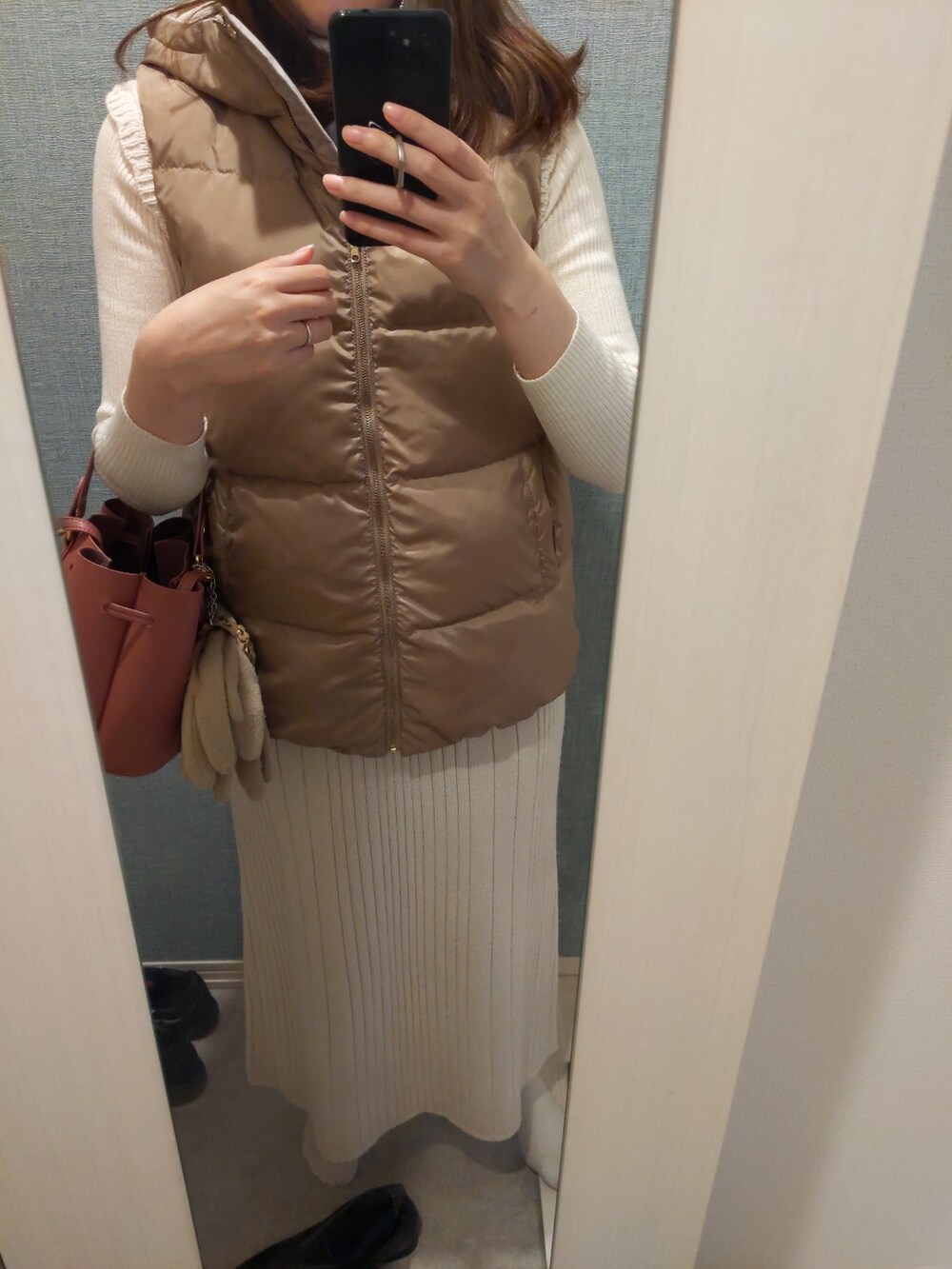 ベージュ系のベスト、ベージュ系のスカートを着用したレディースの冬コーディネートの2枚目の写真