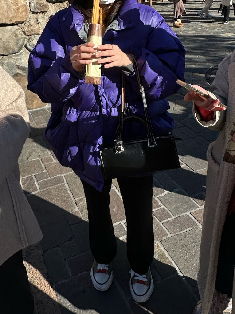 ブラック系のスラックス、その他のスニーカー、パープル系のダウンジャケット/コートを着用したレディースの冬コーディネートの3枚目の写真