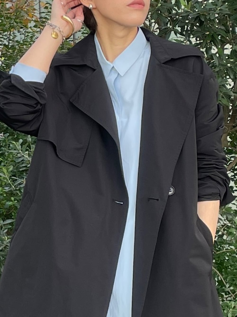 ブラック系のトレンチコート、グレー系のその他パンツ、ホワイト系のスニーカーを着用したレディースの秋コーディネートの4枚目の写真