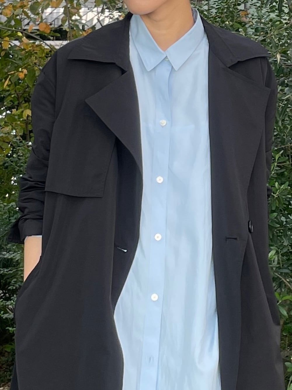 ブラック系のトレンチコート、グレー系のその他パンツ、ホワイト系のスニーカーを着用したレディースの秋コーディネートの3枚目の写真