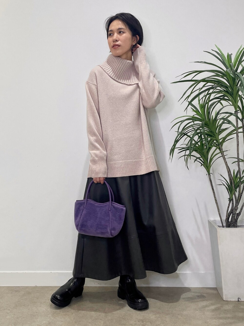 パープル系のニット/セーター、グレー系のステンカラーコート、グレー系のスカートを着用したレディースの冬コーディネートの5枚目の写真