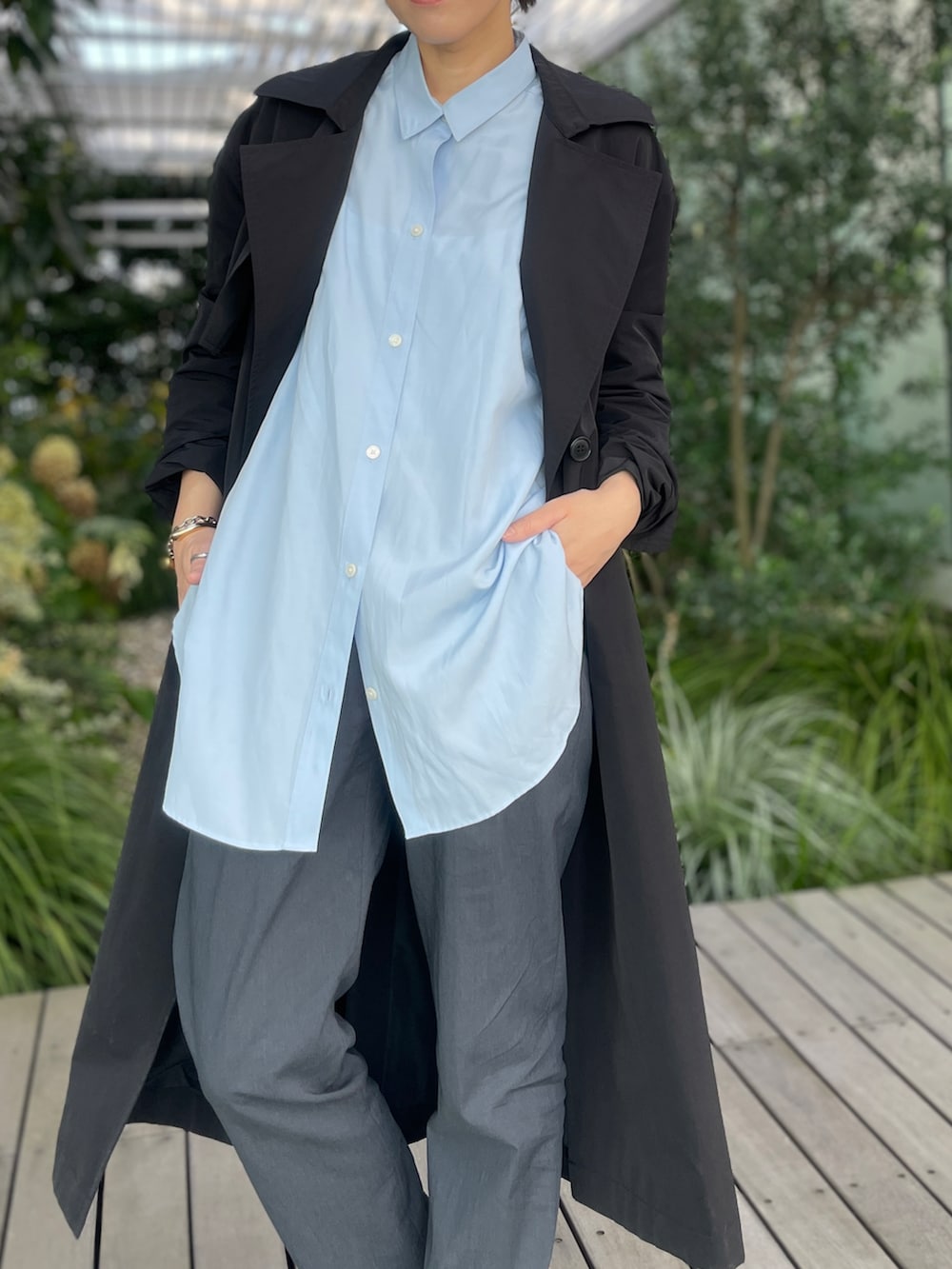 ブラック系のトレンチコート、グレー系のその他パンツ、ホワイト系のスニーカーを着用したレディースの秋コーディネートの5枚目の写真