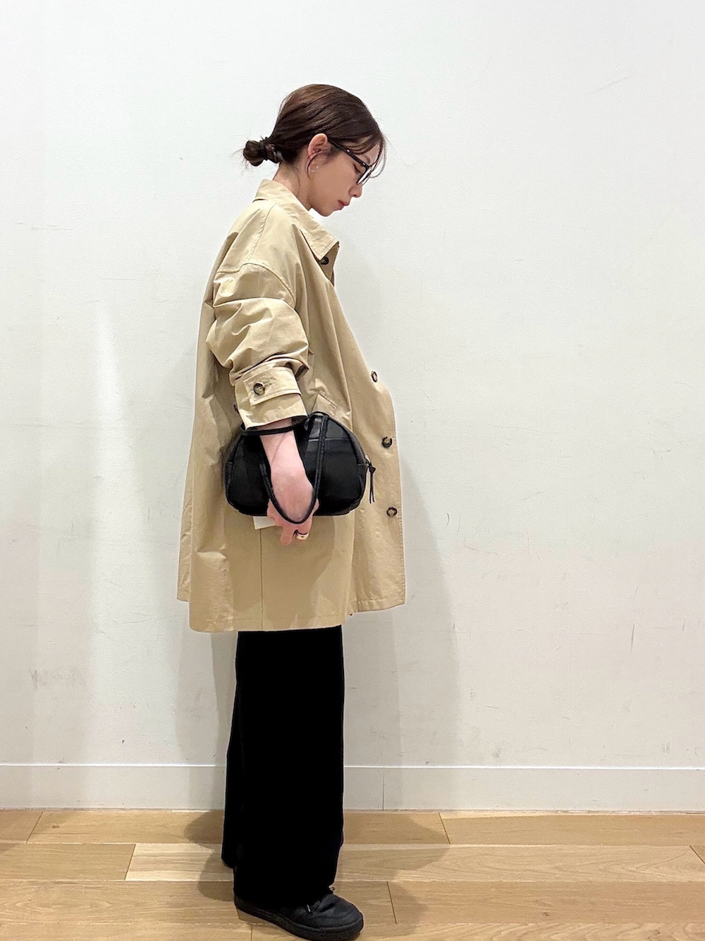 ブラウン系のTシャツ/カットソー、ベージュ系のステンカラーコート、ブラック系のその他パンツを着用したレディースの春コーディネートの5枚目の写真