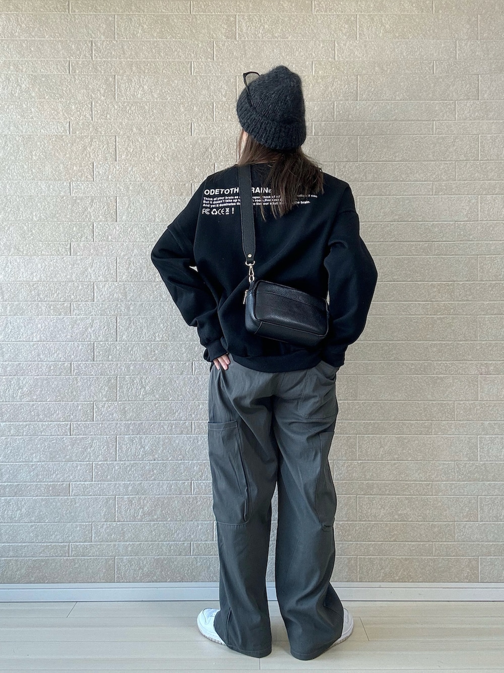 ブラック系のスウェット、グレー系のカーゴパンツ、ホワイト系のスニーカーを着用したレディースの冬コーディネートの4枚目の写真