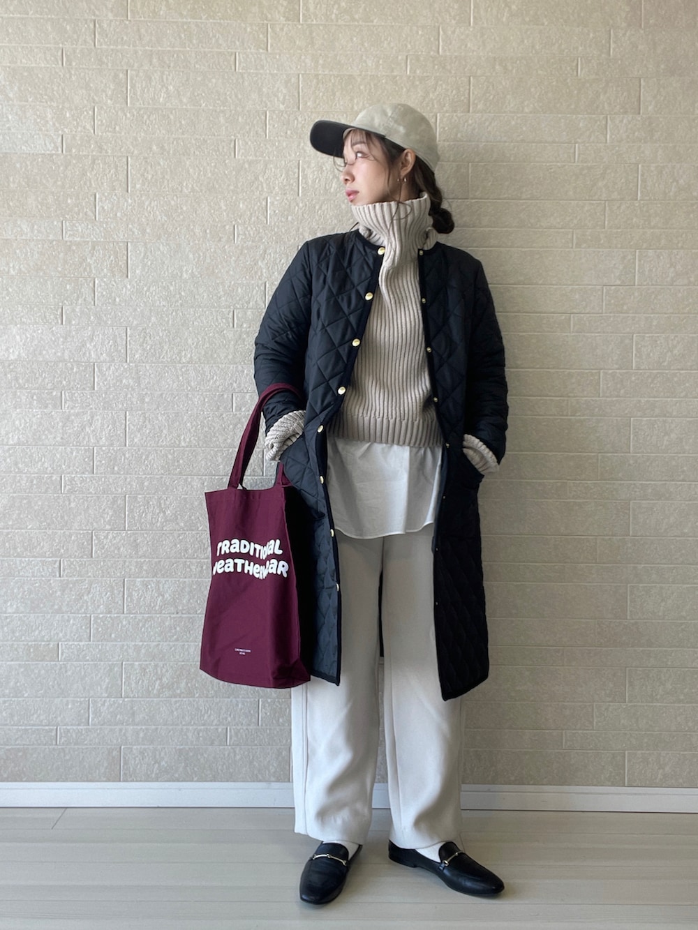 ブラック系のその他アウター、レッド系のトートバッグ、ブラウン系のニット/セーターを着用したレディースの秋コーディネートの2枚目の写真