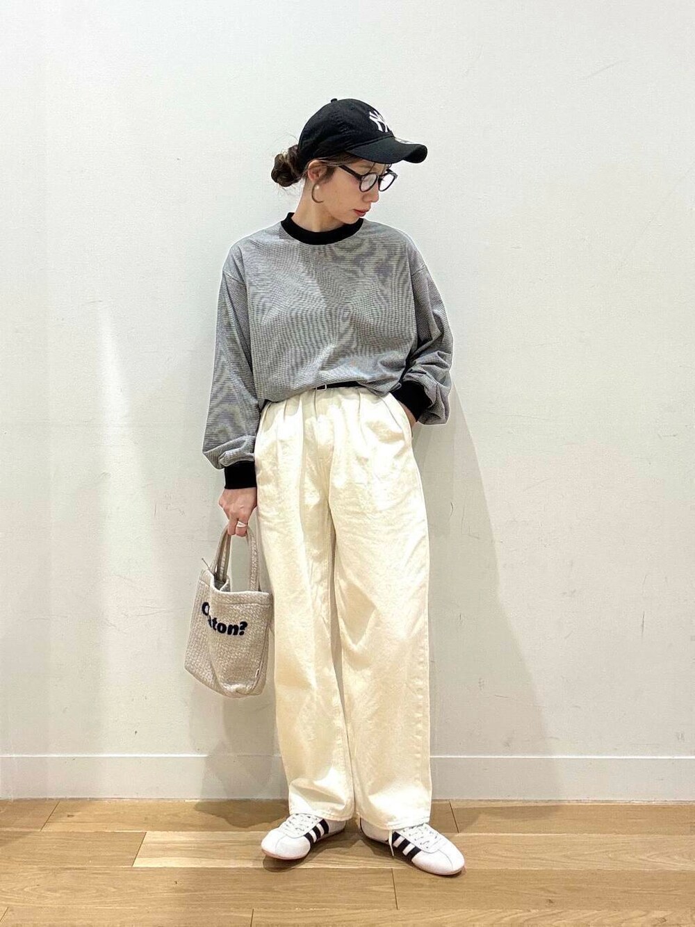 グレー系のカーディガン/ボレロ、ホワイト系のデニムパンツ、グレー系のトートバッグを着用したレディースの冬コーディネートの4枚目の写真