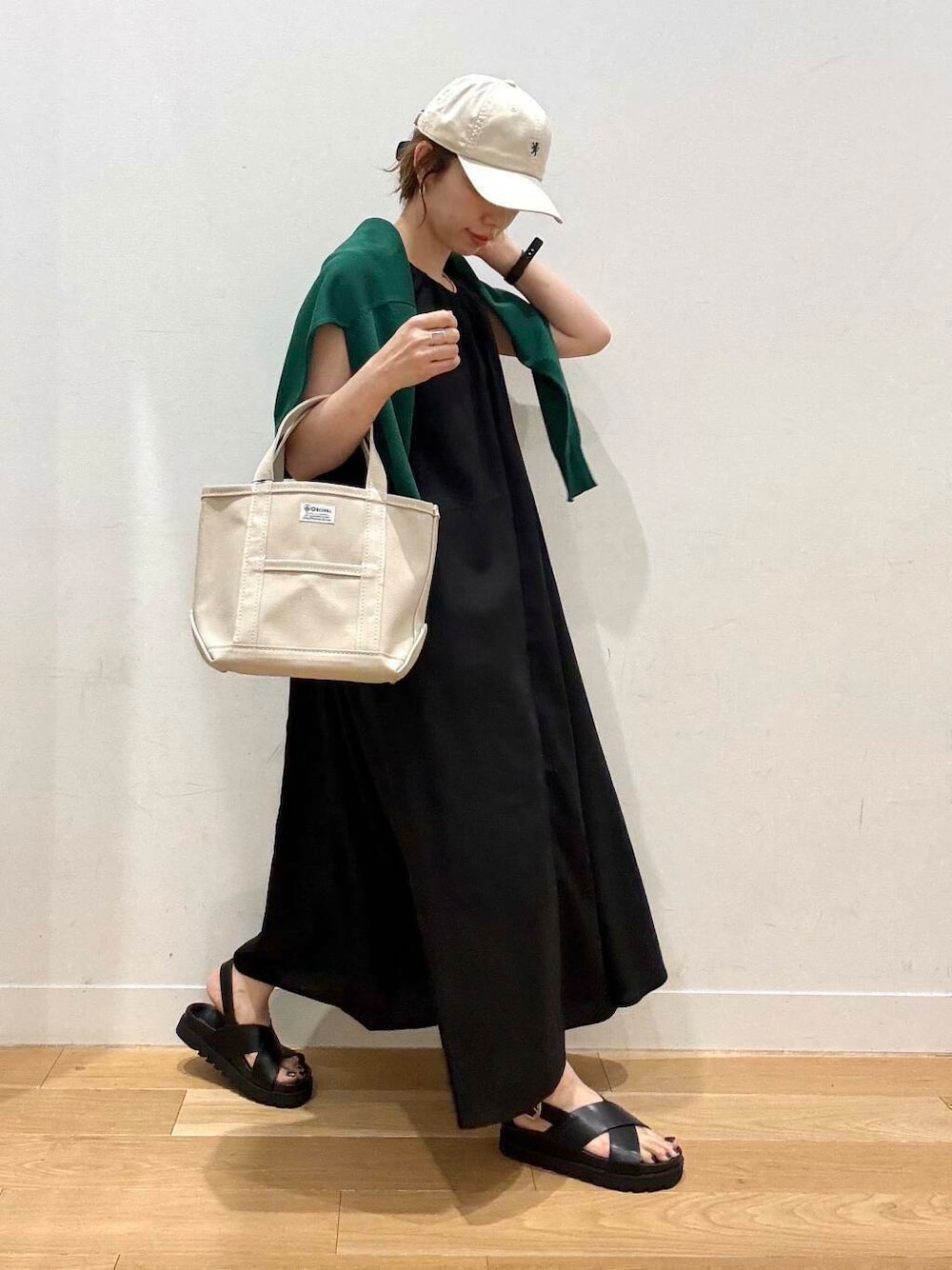 ブラック系のサンダル、グリーン系のカーディガン/ボレロ、ブラック系のワンピースを着用したレディースの夏コーディネートの6枚目の写真