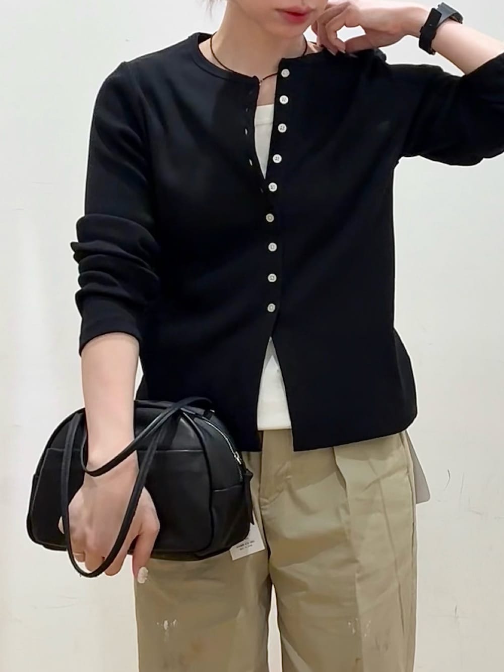 ブラック系のボストンバッグ、ブラック系のローファー、ホワイト系のタンクトップを着用したレディースの春コーディネートの4枚目の写真