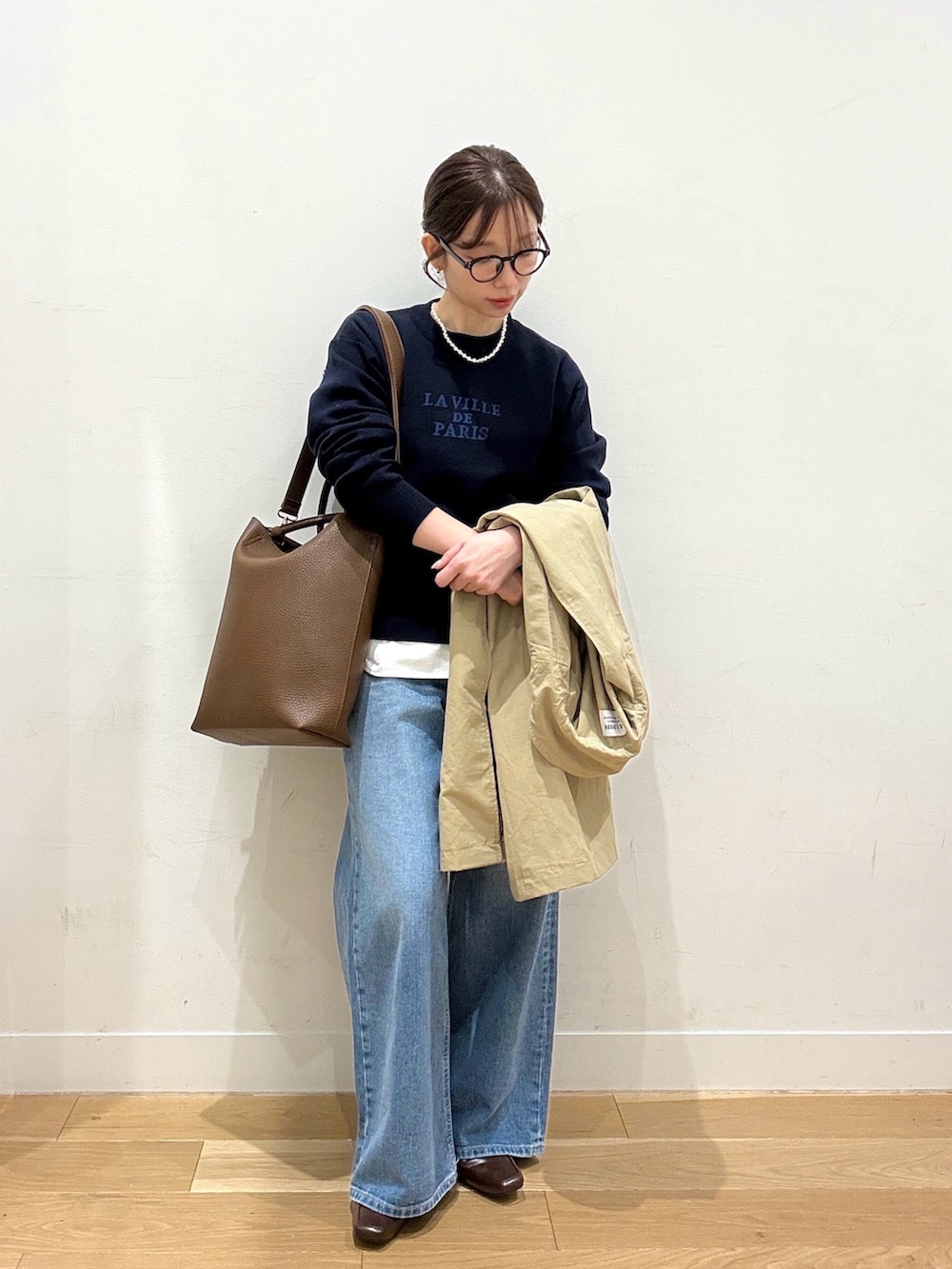 ブルー系のニット/セーター、ホワイト系のTシャツ/カットソー、ブラウン系のトートバッグを着用したレディースの冬コーディネートの3枚目の写真