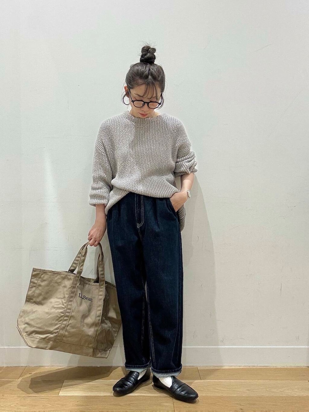 ブラック系のローファー、ブルー系のデニムパンツ、グレー系のニット/セーターを着用したレディースの春コーディネートの4枚目の写真