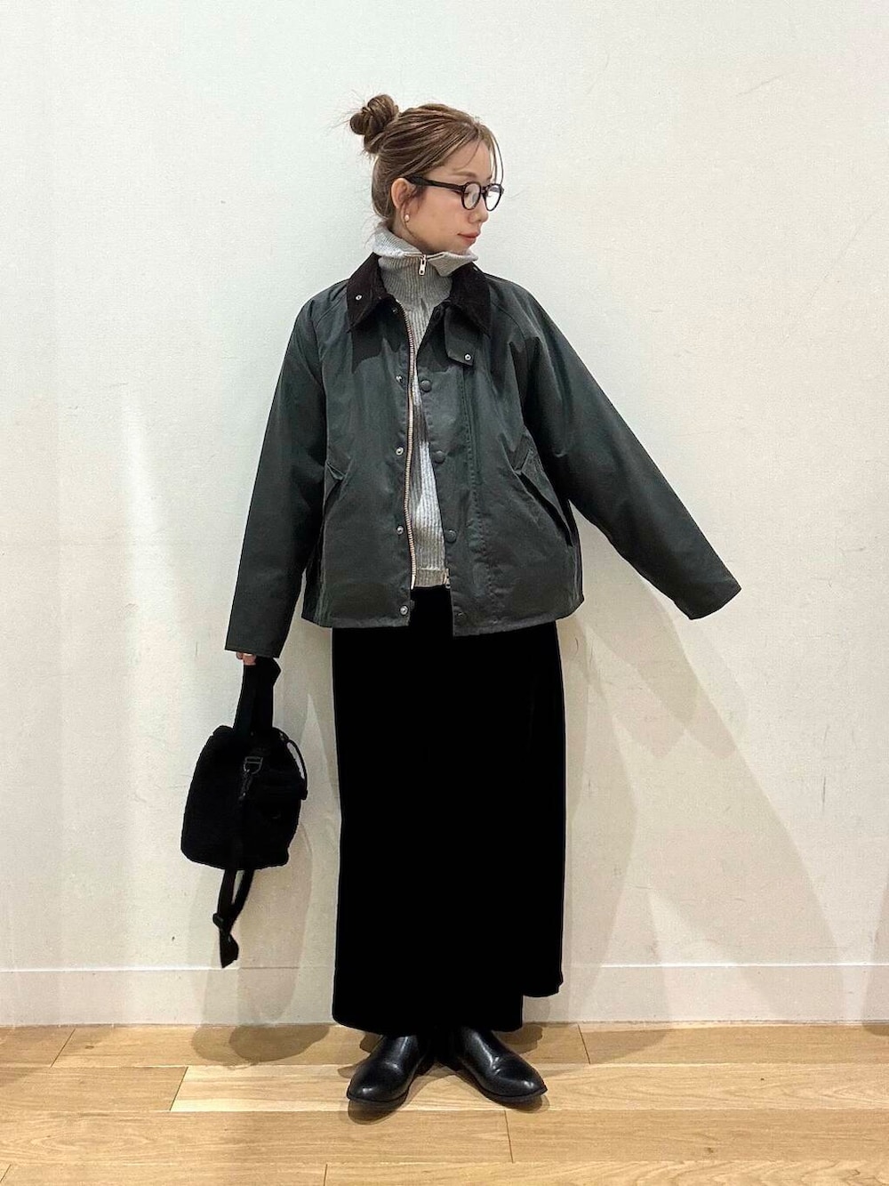 ブラック系のブーツ、グレー系のカーディガン/ボレロ、ブラック系のスカートを着用したレディースの冬コーディネートの2枚目の写真