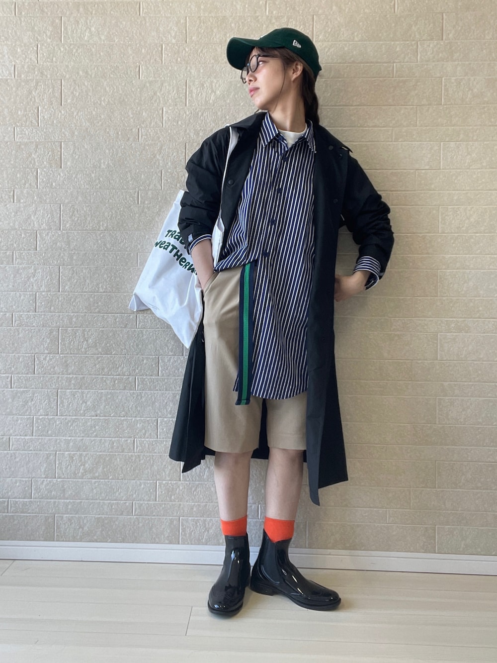 ホワイト系のトートバッグ、ブラック系のレインシューズ、ブルー系のシャツ/ブラウスを着用したレディースの春コーディネートの2枚目の写真