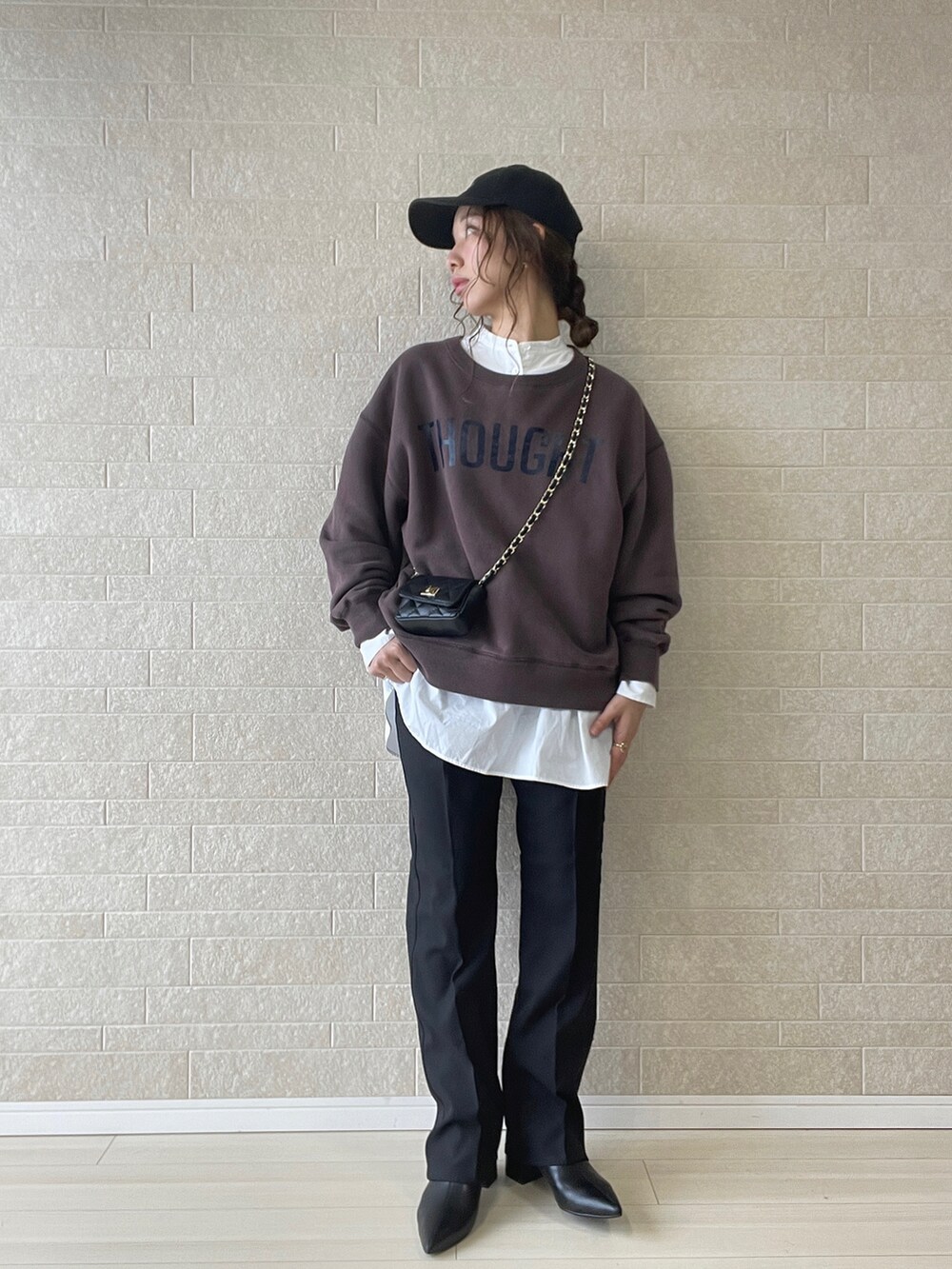 ブラック系のスラックス、ブラック系のブーツ、ブラウン系のスウェットを着用したレディースの秋コーディネートの2枚目の写真