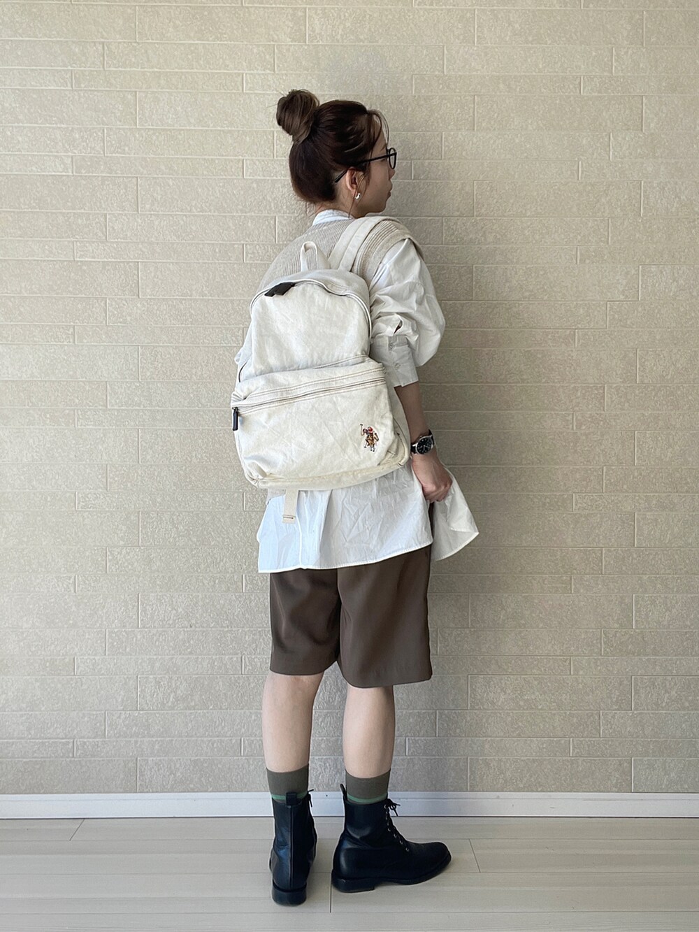 ホワイト系のバックパック/リュック、ベージュ系のベスト、ブラウン系のその他パンツを着用したレディースの冬コーディネートの2枚目の写真