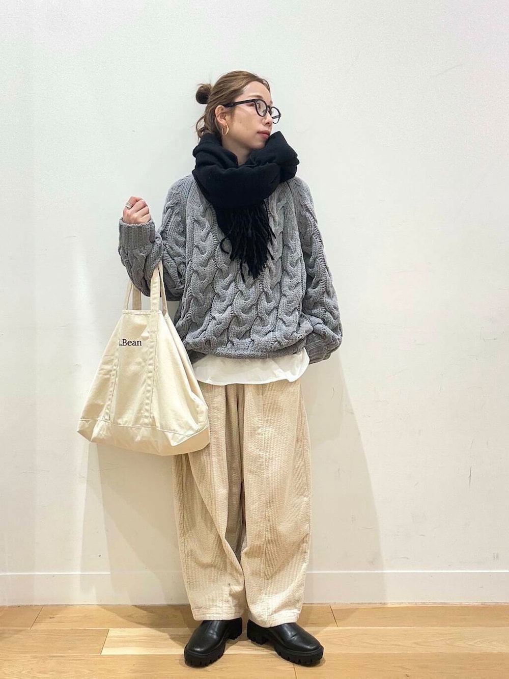 ホワイト系のトートバッグ、ブラック系のブーツ、ホワイト系のTシャツ/カットソーを着用したレディースの冬コーディネートの4枚目の写真