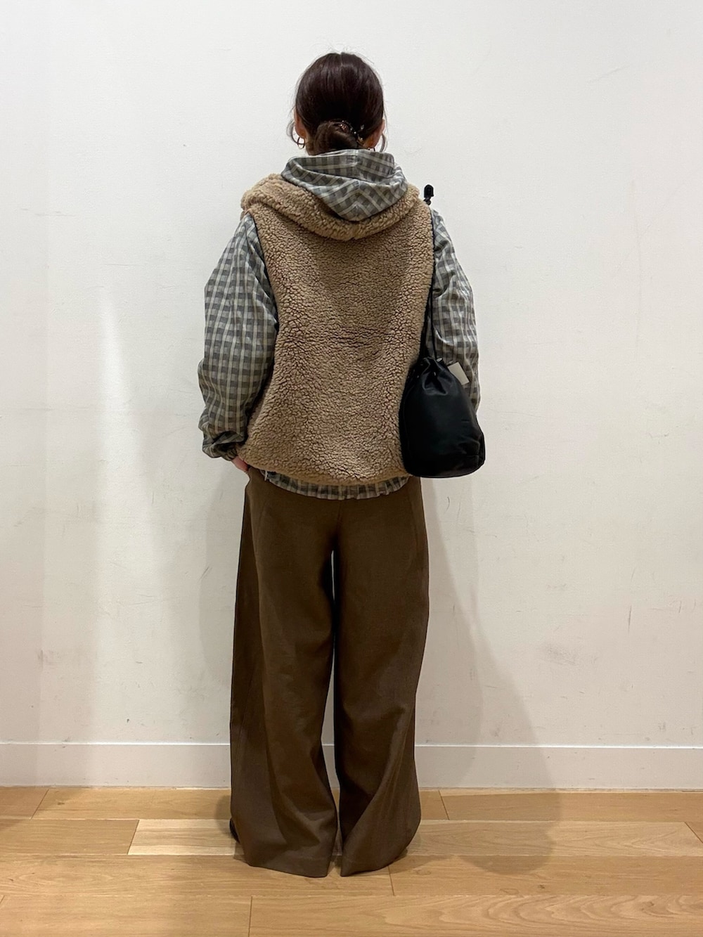 ベージュ系のダウンベスト、レッド系のTシャツ/カットソー、ブラック系のローファーを着用したレディースの秋コーディネートの2枚目の写真