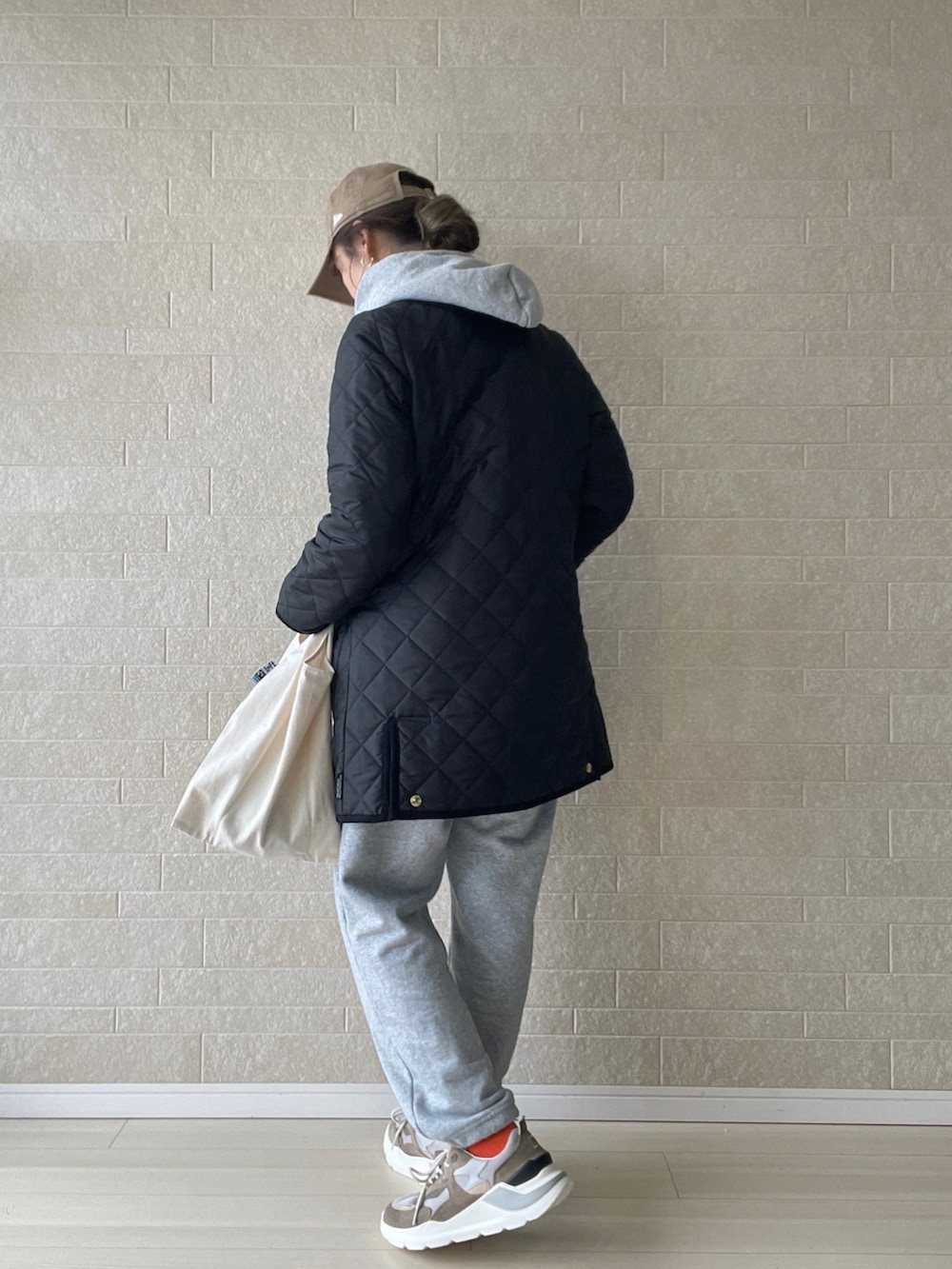 ブラック系のその他アウター、ベージュ系のスニーカー、グレー系のスウェットパンツを着用したレディースの冬コーディネートの5枚目の写真