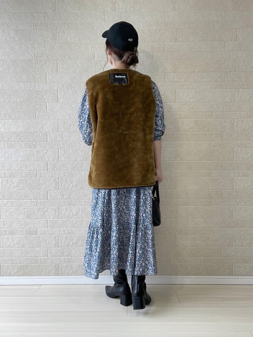 ブラック系のブーツ、グレー系のワンピース、ブラウン系のベストを着用したレディースの秋コーディネートの5枚目の写真