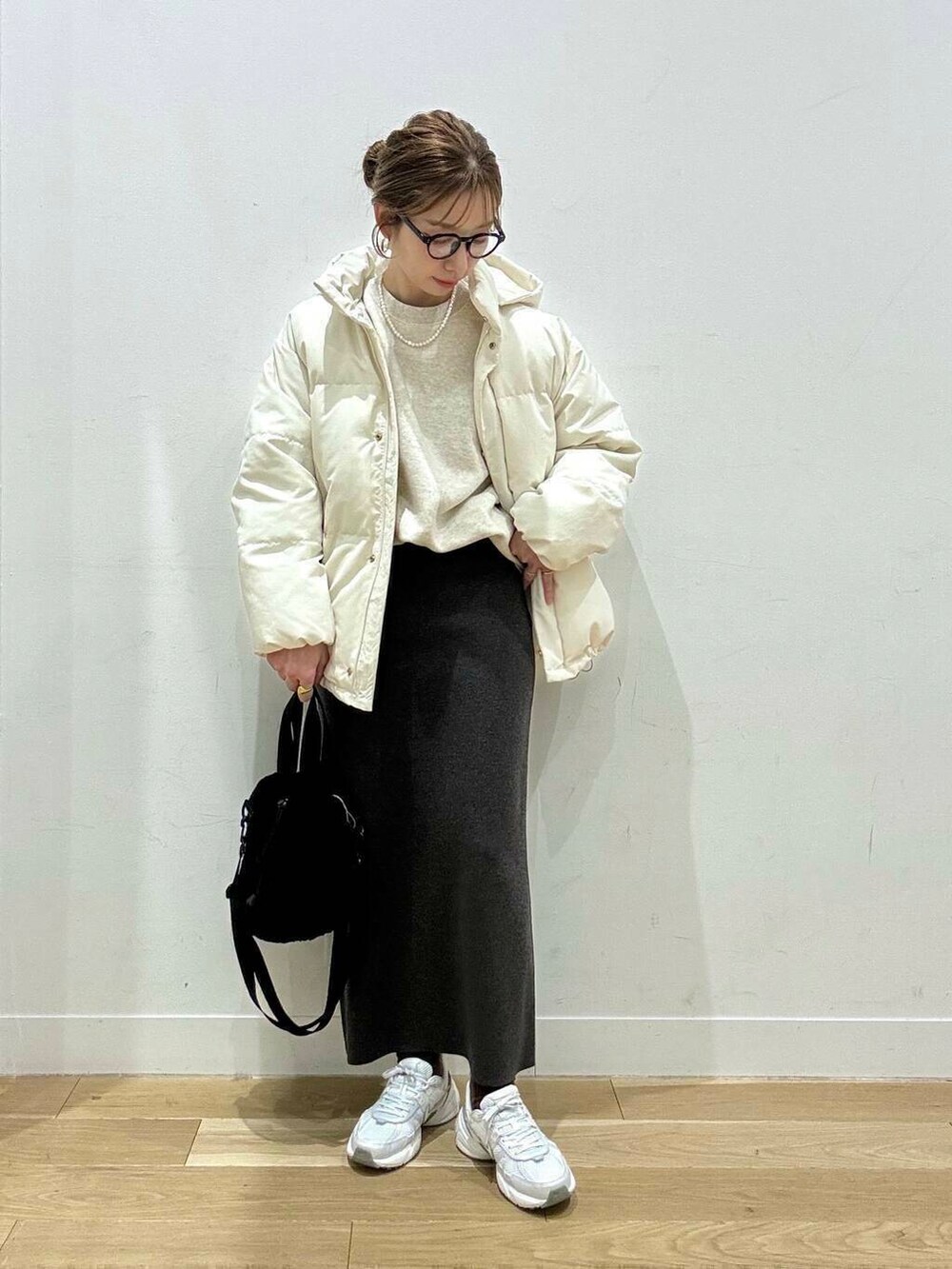 ホワイト系のスニーカー、グレー系のスカート、ホワイト系のダウンジャケット/コートを着用したレディースの冬コーディネートの2枚目の写真