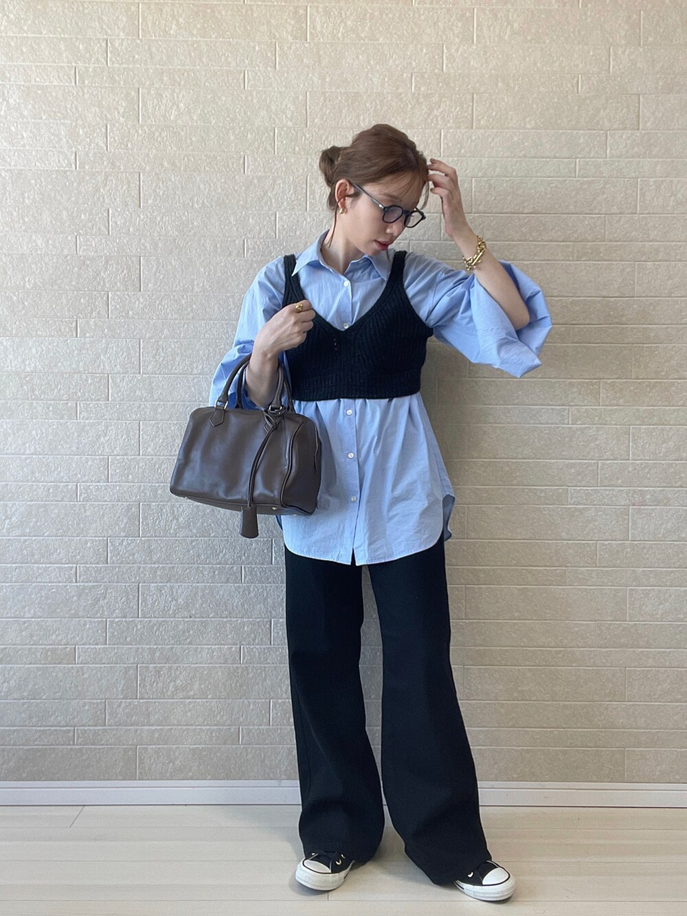 ブラック系のデニムパンツ、グレー系のニット/セーター、ブラウン系のボストンバッグを着用したレディースの秋コーディネートの3枚目の写真