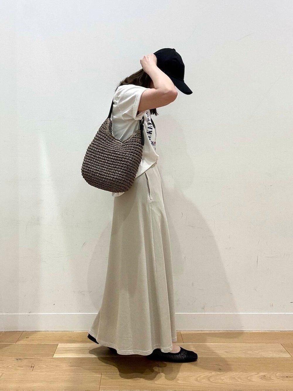 グレー系のトートバッグ、イエロー系のサンダル、ホワイト系のTシャツ/カットソーを着用したレディースの夏コーディネートの2枚目の写真