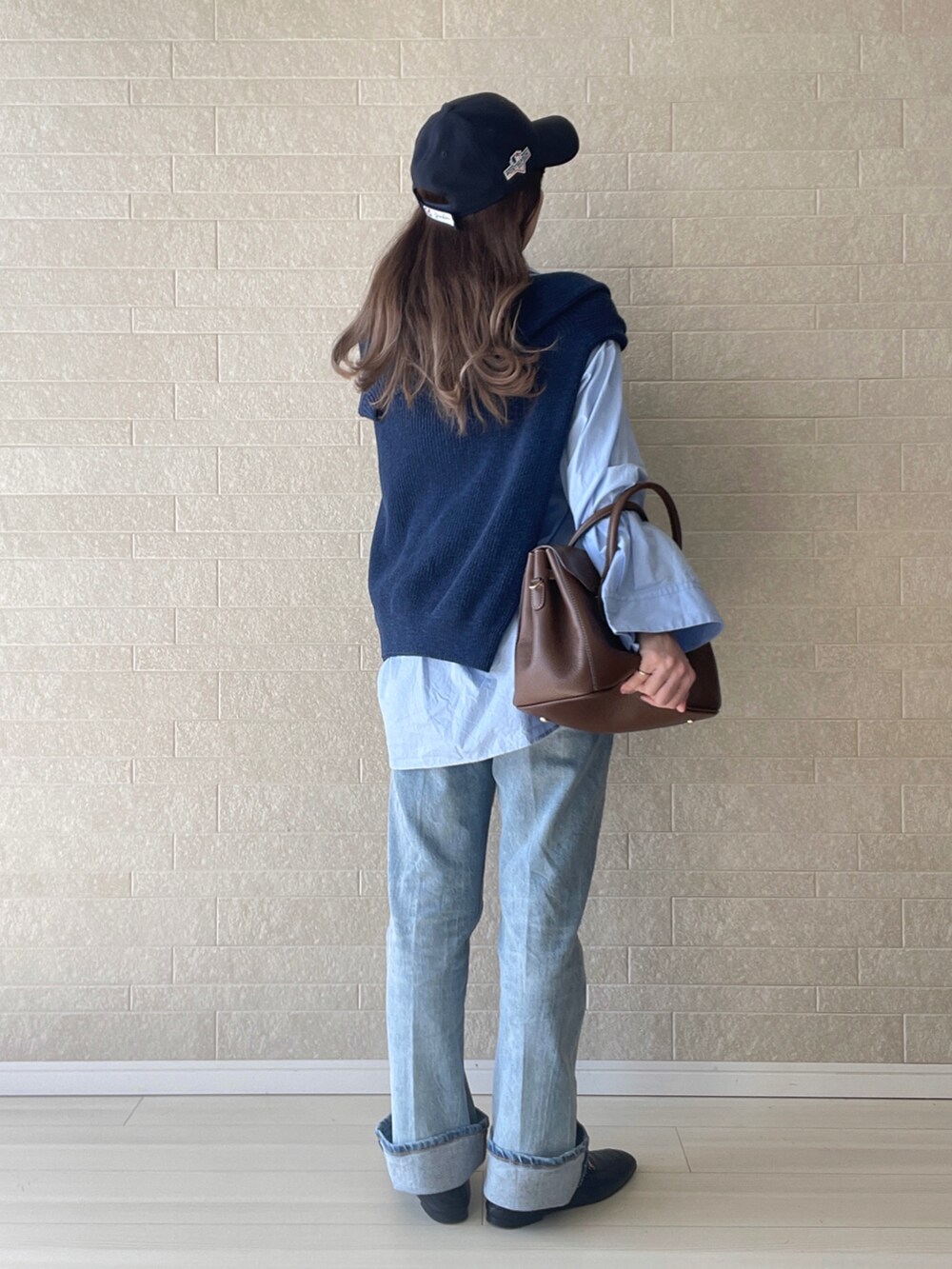 ブルー系のデニムパンツ、ブラック系のローファー、ブルー系のニット/セーターを着用したレディースの秋コーディネートの3枚目の写真