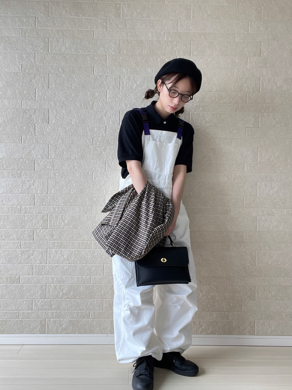 ホワイト系のサロペット/オーバーオール、ブラック系のポロシャツ、ブラック系のショルダーバッグを着用したレディースの秋コーディネートの3枚目の写真