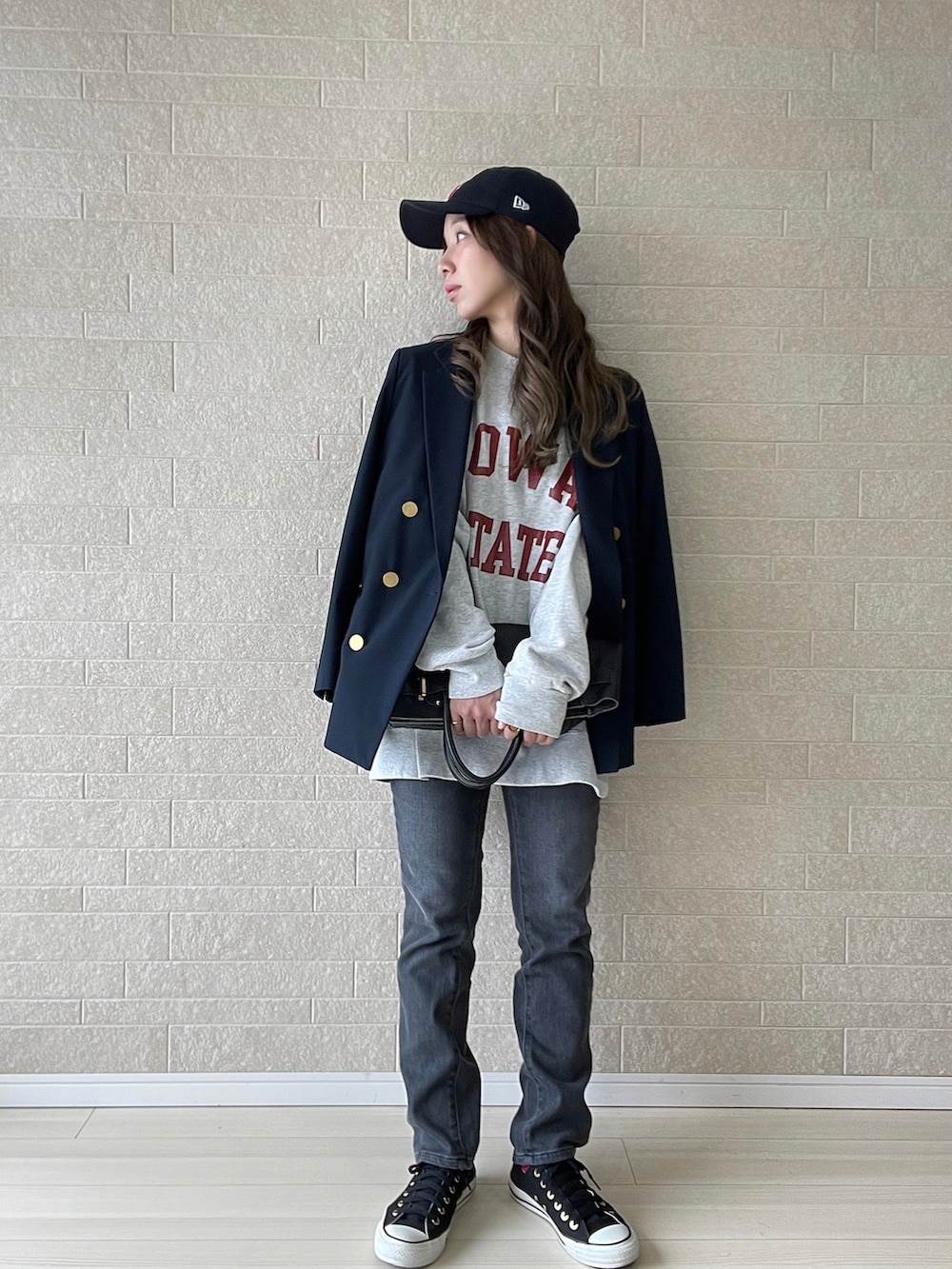 グレー系のデニムパンツ、ブルー系のテーラードジャケット、ブラック系のスニーカーを着用したレディースの冬コーディネートの2枚目の写真