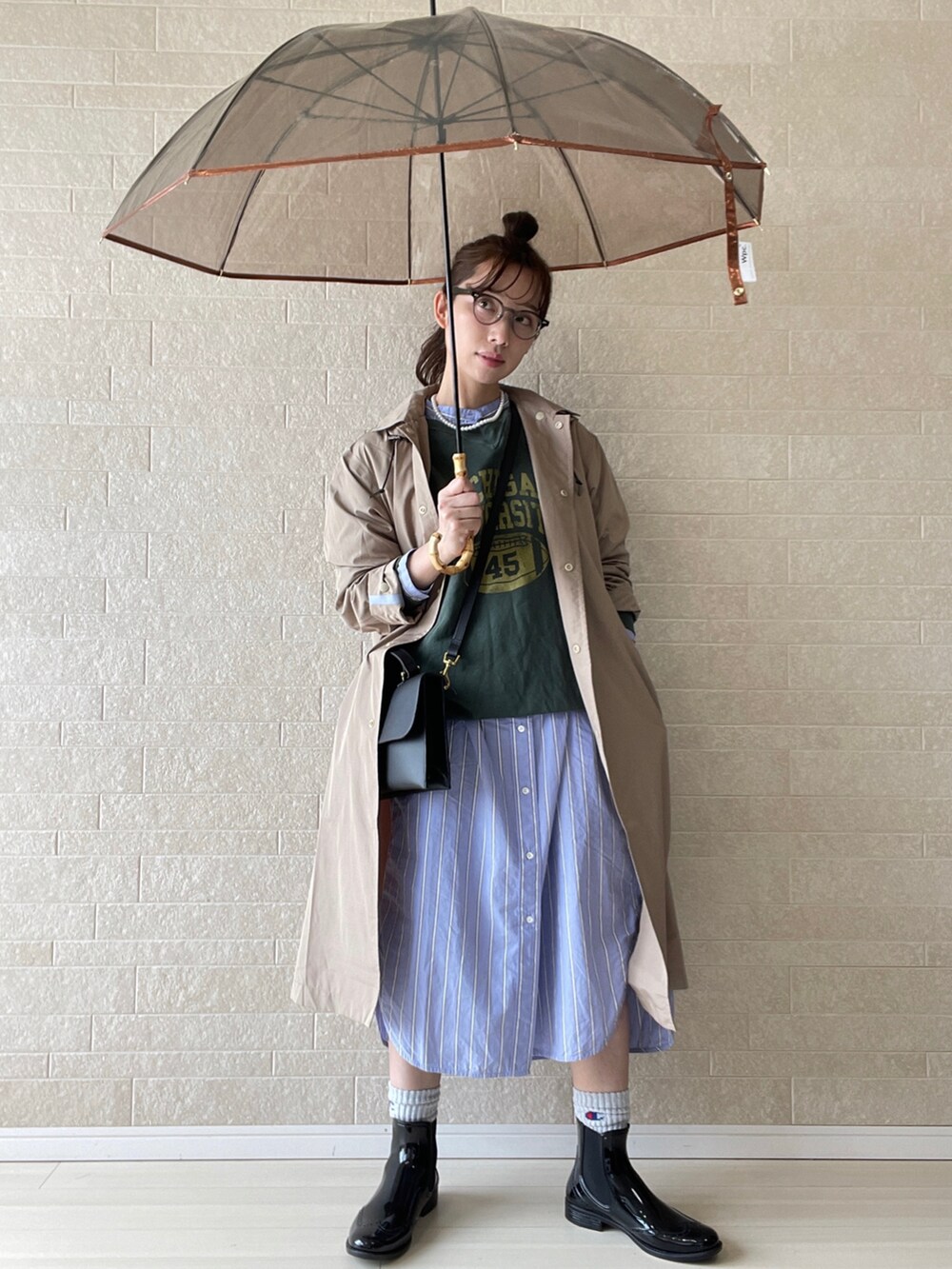 ブラック系のレインシューズ、ブラック系のショルダーバッグ、ブルー系のシャツワンピースを着用したレディースの春コーディネートの4枚目の写真