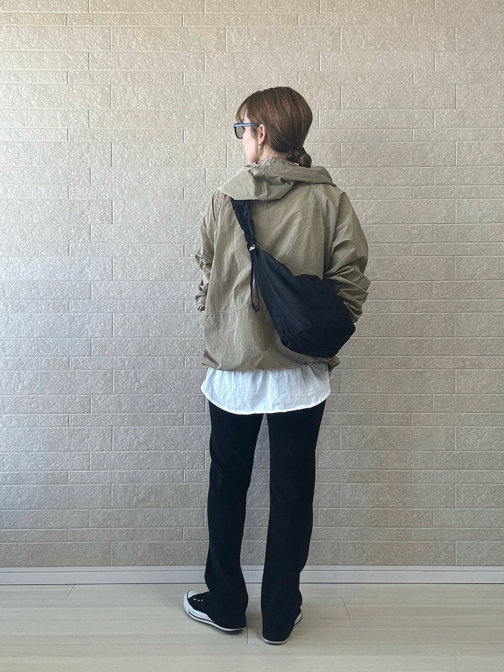 ベージュ系のナイロンジャケット、ホワイト系のTシャツ/カットソー、ブラック系のスニーカーを着用したレディースの春コーディネートの4枚目の写真