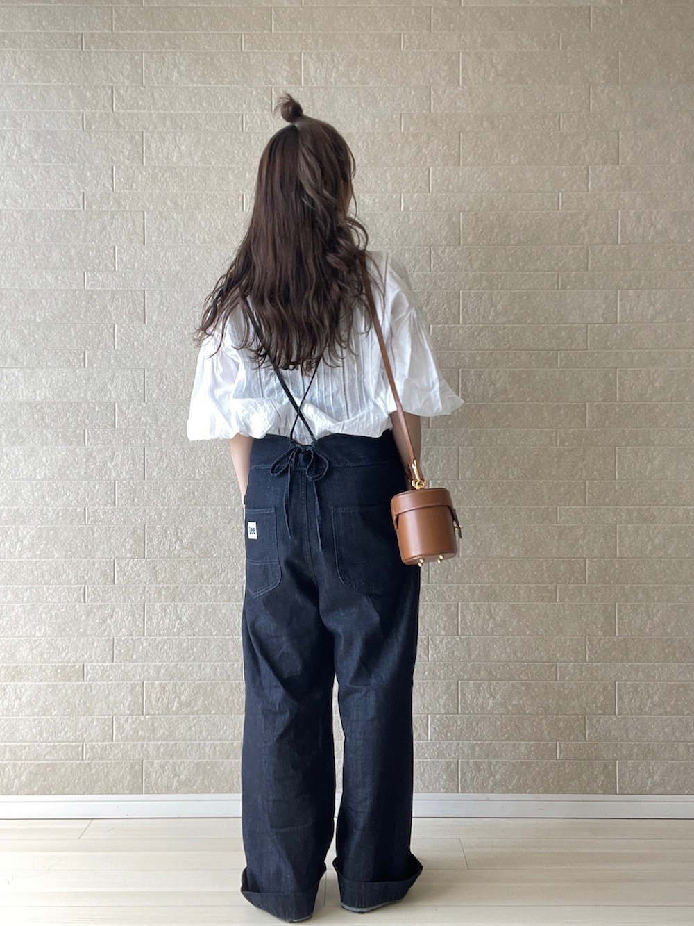 ブルー系のサロペット/オーバーオール、ブラック系のパンプス、イエロー系のハンドバッグを着用したレディースの春コーディネートの3枚目の写真