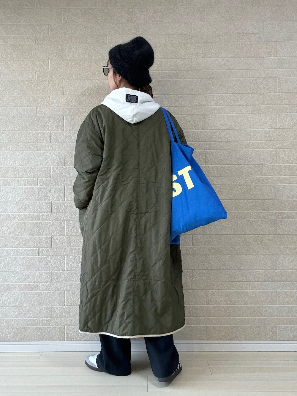 グリーン系のその他アウター、ホワイト系のパーカー、グレー系のその他パンツを着用したレディースの冬コーディネートの2枚目の写真