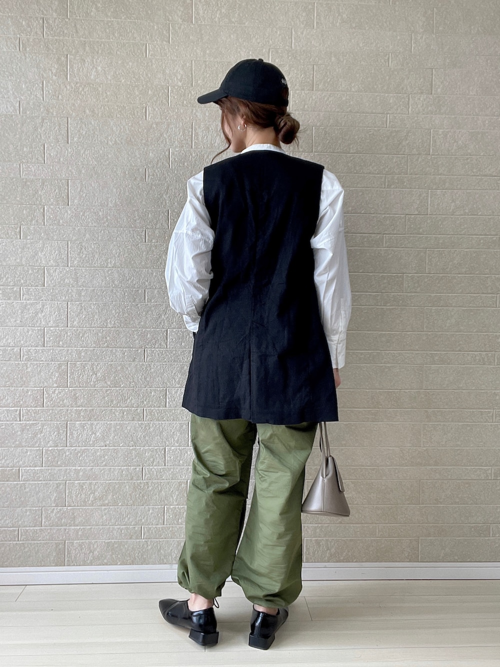 グリーン系のカーゴパンツ、ブラック系のパンプス、グレー系のショルダーバッグを着用したレディースの春コーディネートの3枚目の写真