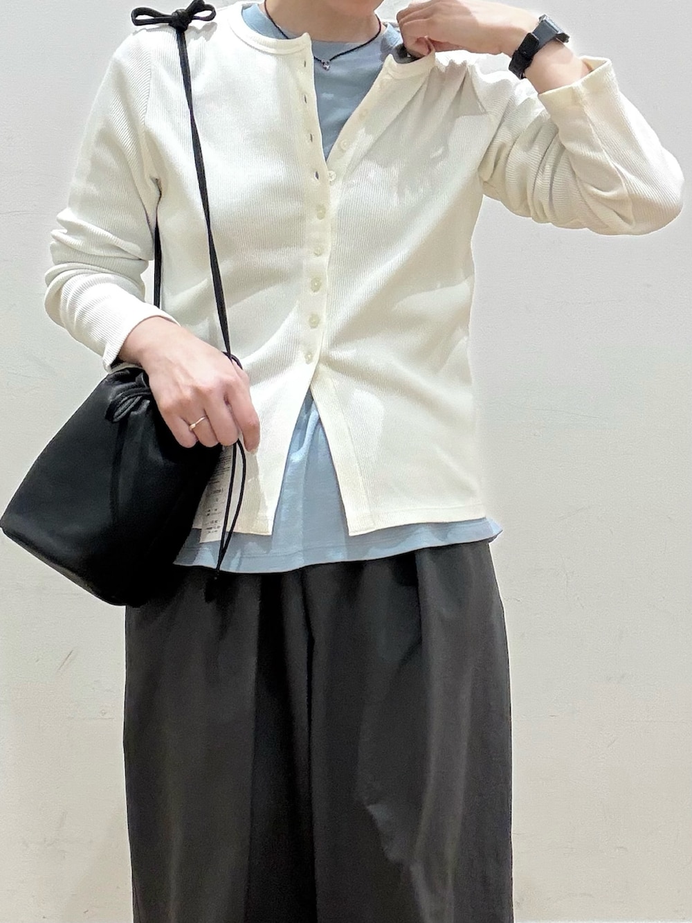 ホワイト系のカーディガン/ボレロ、ブルー系のTシャツ/カットソー、ブラック系のショルダーバッグを着用したレディースの春コーディネートの4枚目の写真