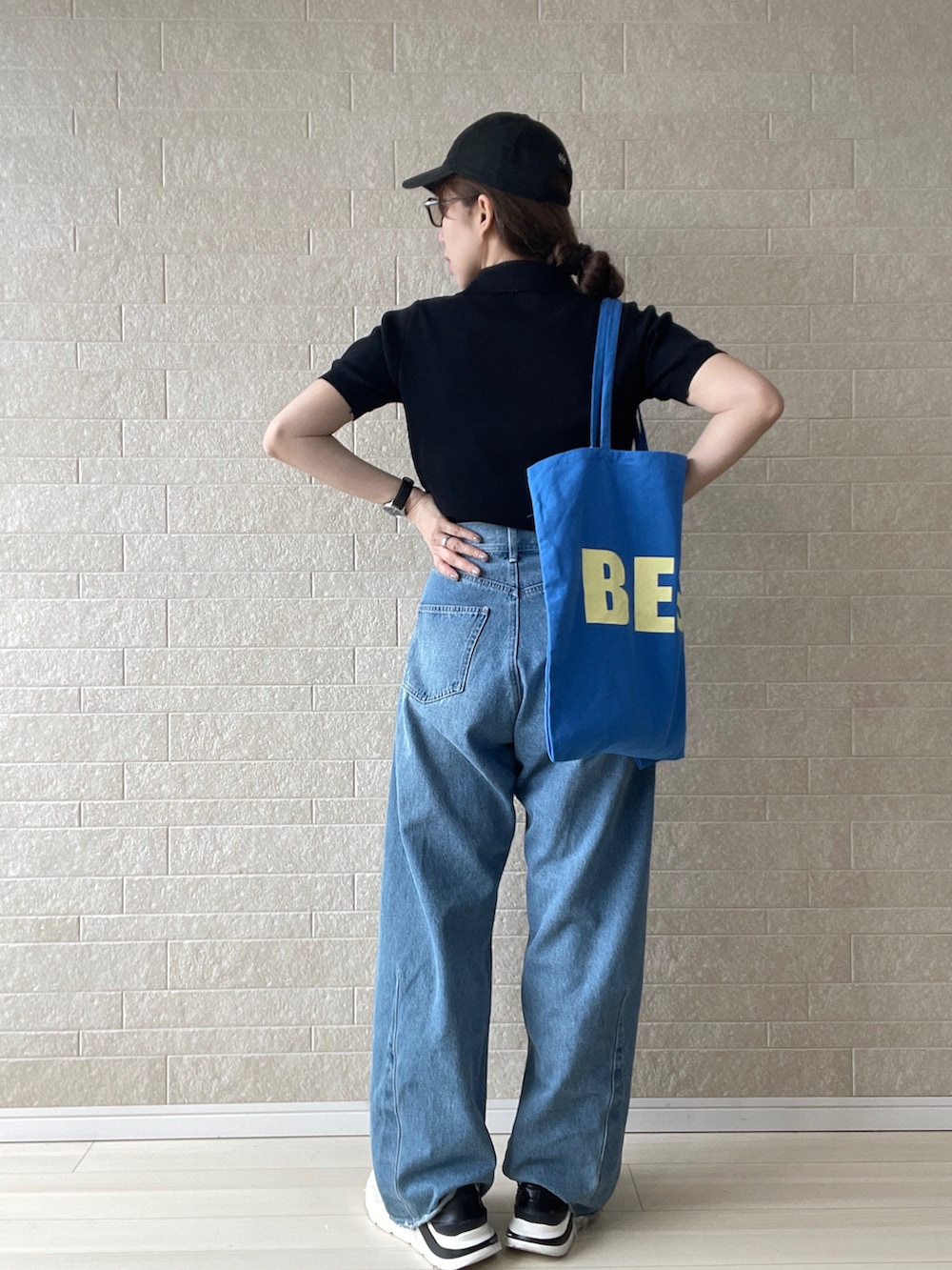 ブラック系のTシャツ/カットソー、ブルー系のトートバッグ、ブルー系のデニムパンツを着用したレディースの夏コーディネートの2枚目の写真