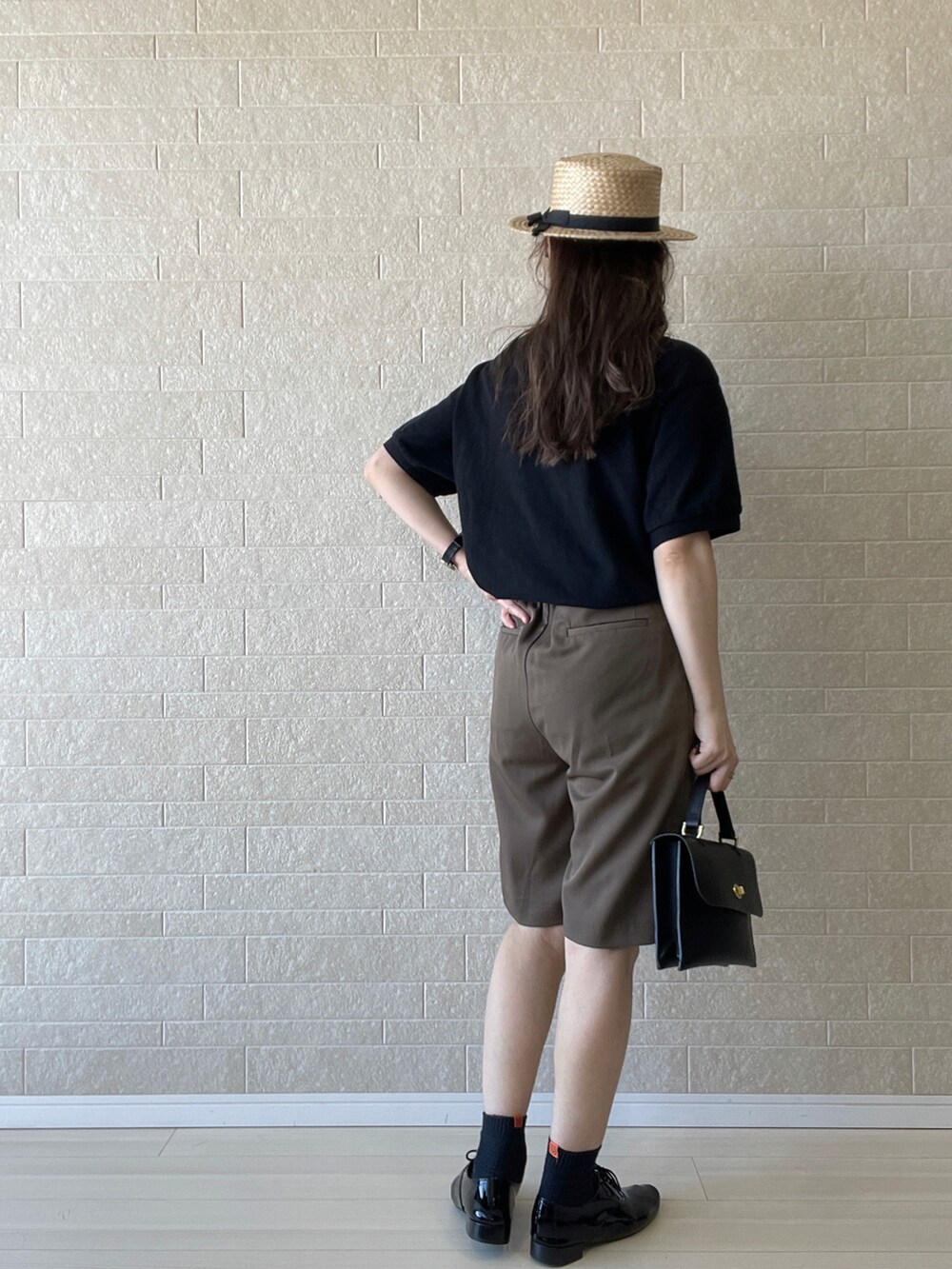 ブラック系のポロシャツ、ブラウン系のその他パンツ、ブラック系のドレスシューズを着用したレディースの夏コーディネートの5枚目の写真