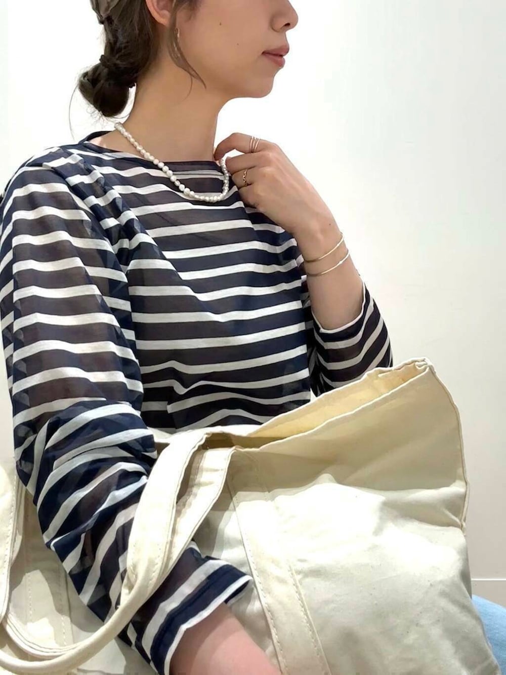 ブルー系のデニムパンツ、ホワイト系のバレエシューズ、ブルー系のTシャツ/カットソーを着用したレディースの春コーディネートの5枚目の写真