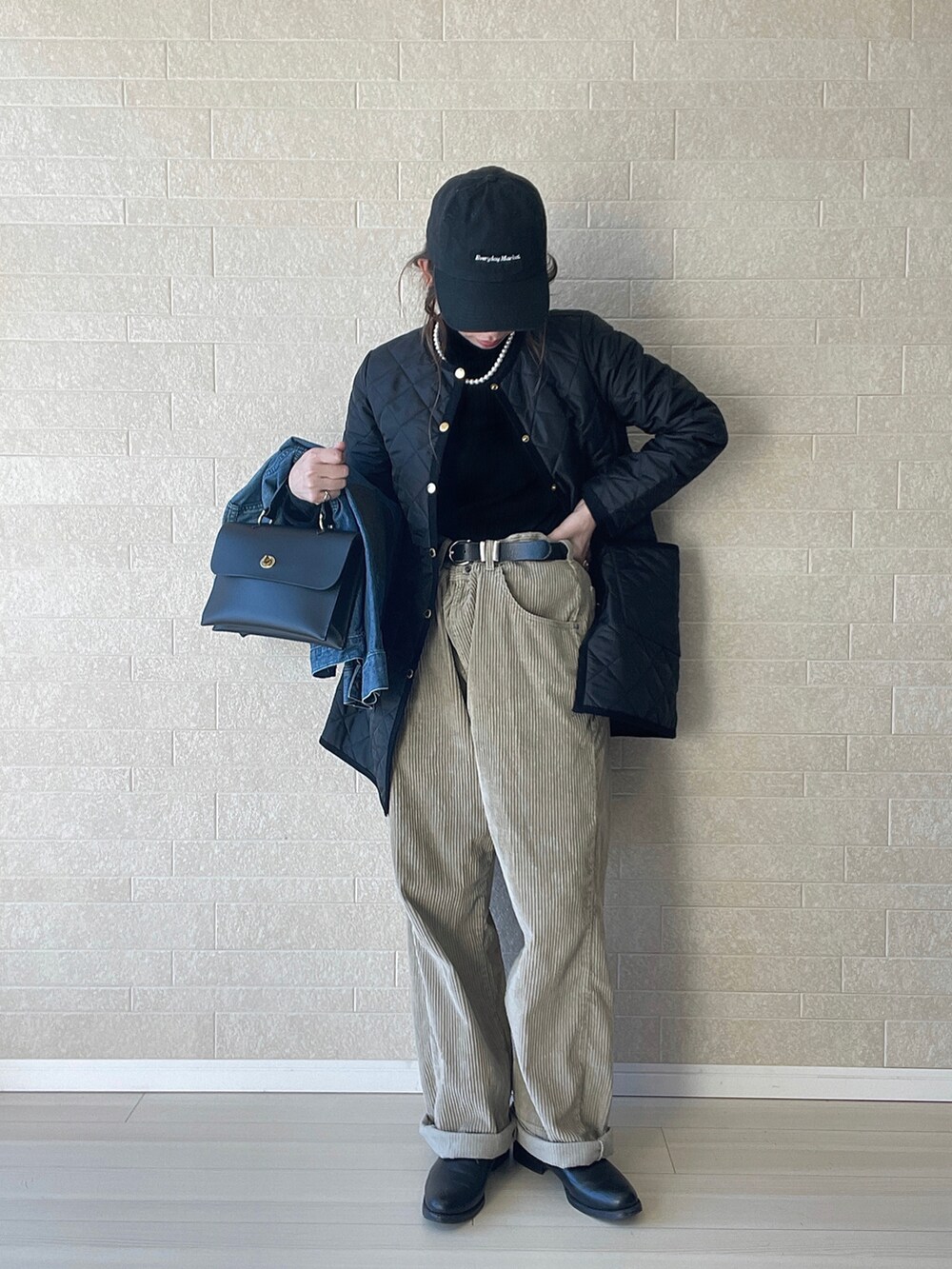 ブラック系のその他アウター、ブラック系のニット/セーター、ベージュ系のパンツを着用したレディースの冬コーディネートの3枚目の写真