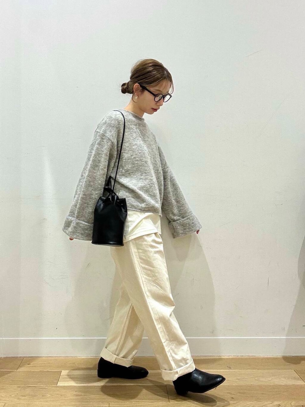 ホワイト系のトートバッグ、ベージュ系のデニムパンツ、ブラック系のブーツを着用したレディースの冬コーディネートの6枚目の写真