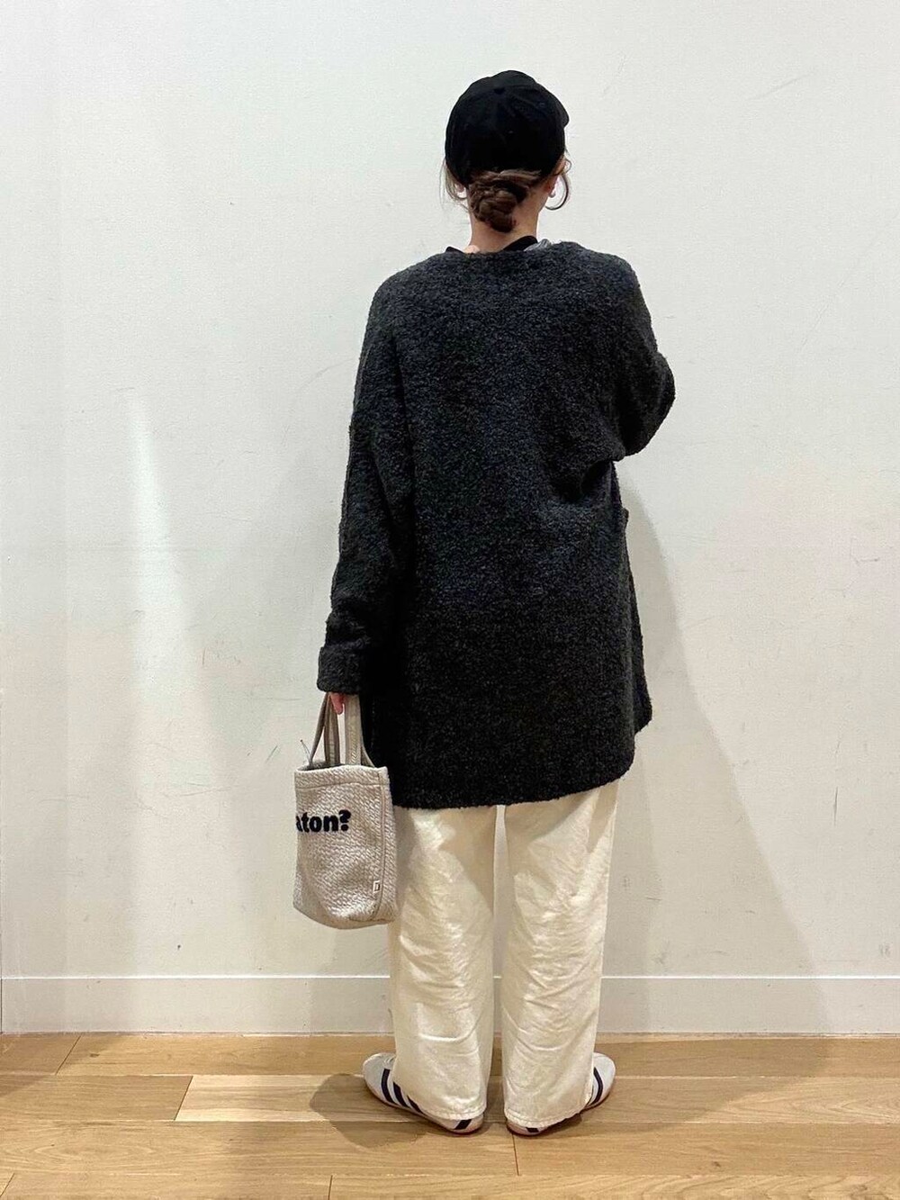 グレー系のカーディガン/ボレロ、ホワイト系のデニムパンツ、グレー系のトートバッグを着用したレディースの冬コーディネートの3枚目の写真