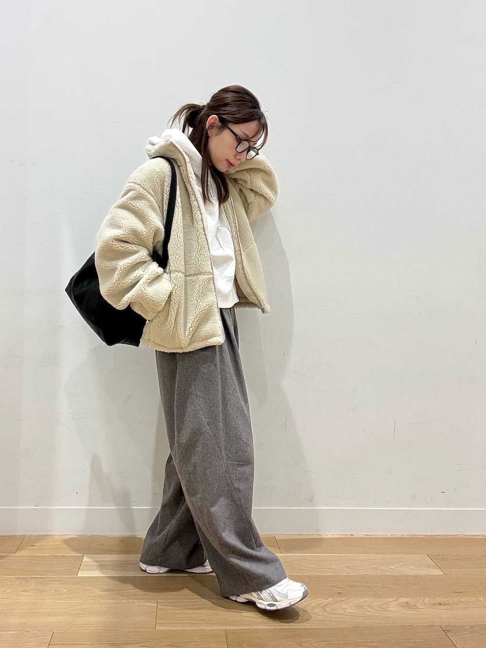 ベージュ系のパーカー、ホワイト系のその他アウター、ブラック系のショルダーバッグを着用したレディースの冬コーディネートの4枚目の写真