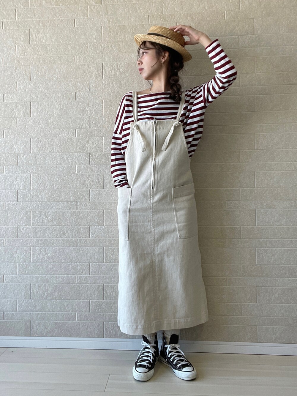 ホワイト系のワンピース、レッド系のTシャツ/カットソー、ブラウン系のスニーカーを着用したレディースの春コーディネートの3枚目の写真