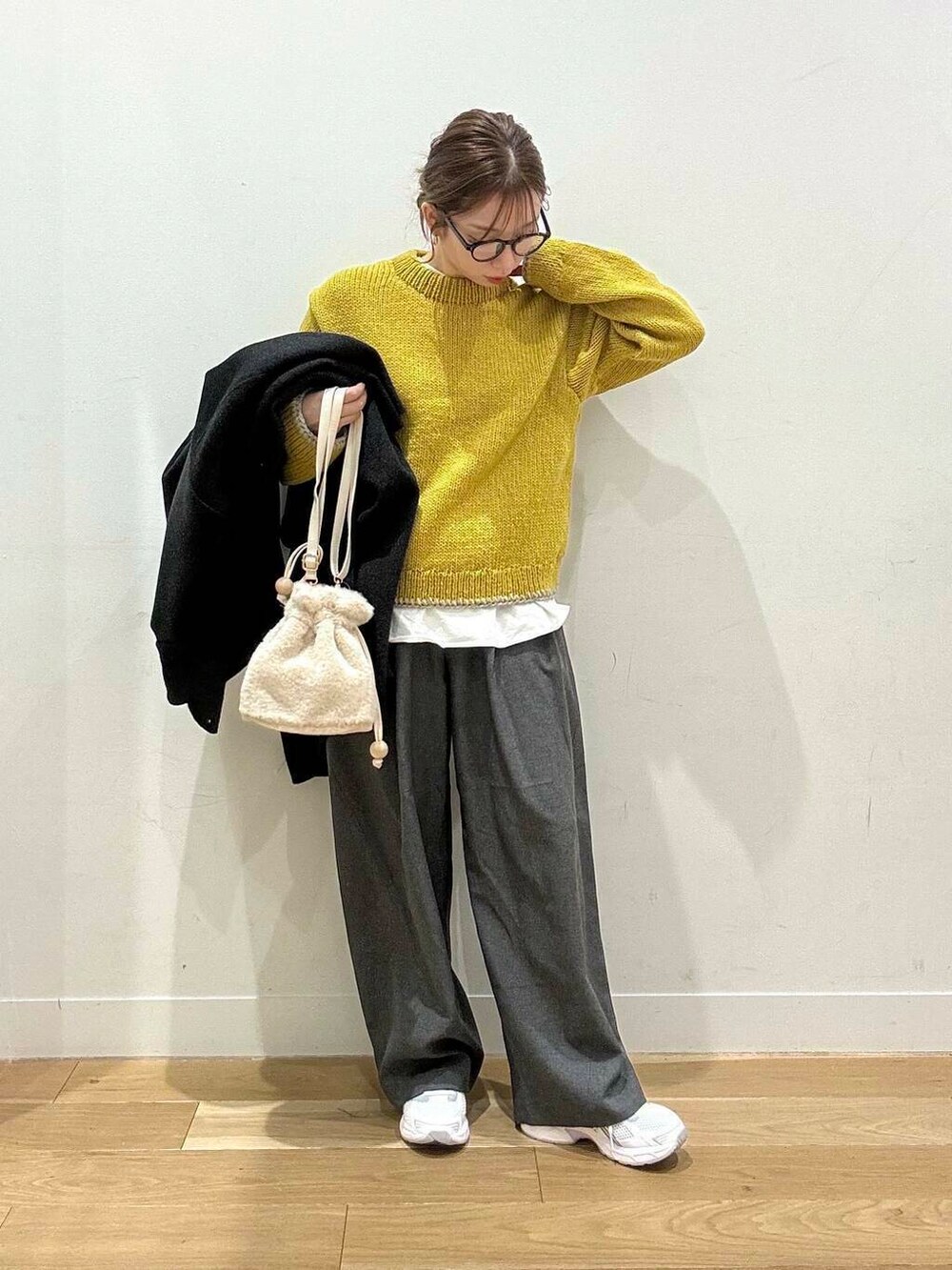 イエロー系のニット/セーター、ホワイト系のスニーカー、グレー系のその他パンツを着用したレディースの秋コーディネートの4枚目の写真