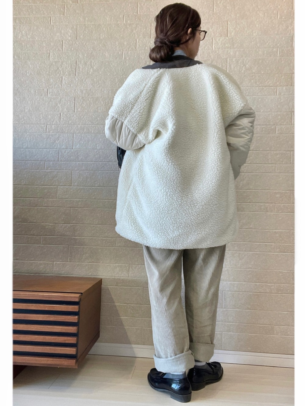 ホワイト系のブルゾン、ベージュ系のパンツ、ブラック系のローファーを着用したレディースの冬コーディネートの3枚目の写真