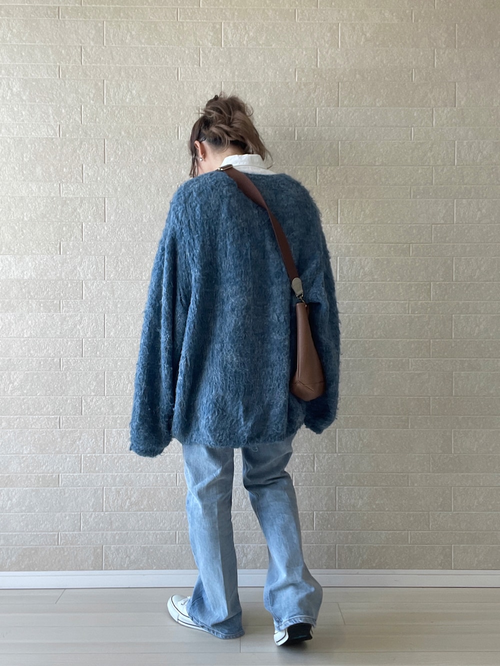 ブルー系のデニムパンツ、ホワイト系のシャツ/ブラウス、ブルー系のニット/セーターを着用したレディースの秋コーディネートの4枚目の写真