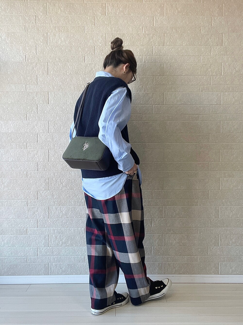 グリーン系のショルダーバッグ、ブルー系のその他パンツ、ブルー系のベストを着用したレディースの冬コーディネートの4枚目の写真