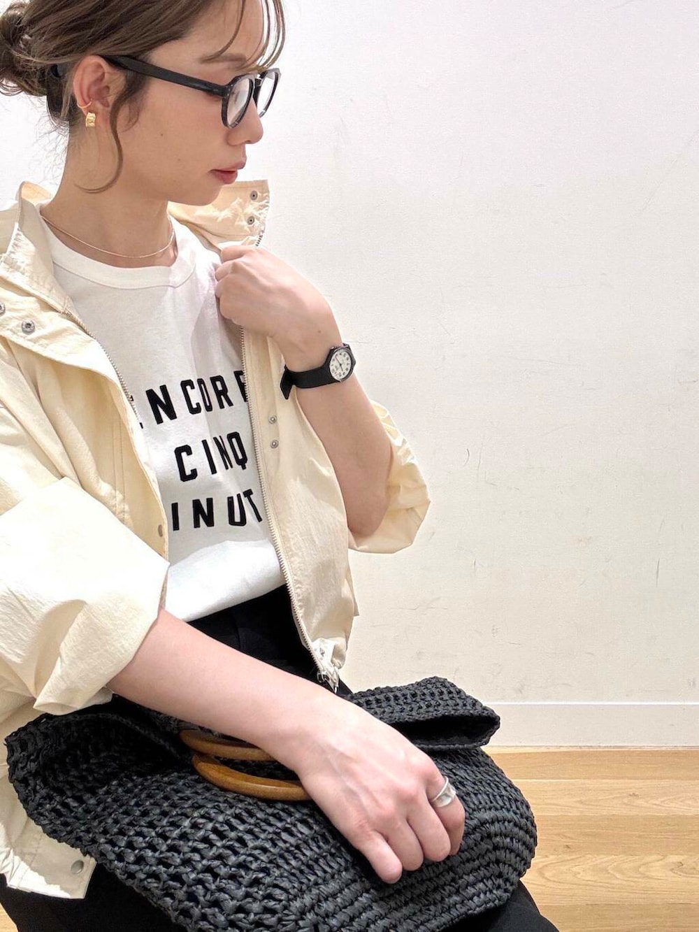 ベージュ系のスニーカー、ホワイト系のマウンテンパーカー、ブラック系のトートバッグを着用したレディースの春コーディネートの6枚目の写真