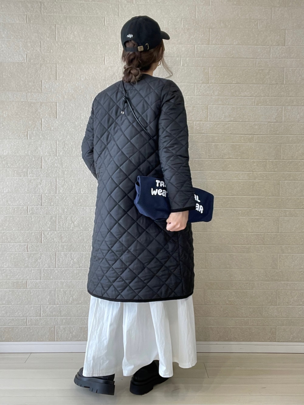 ブラック系のその他アウター、ブルー系のトートバッグ、ブラウン系のベストを着用したレディースの冬コーディネートの4枚目の写真