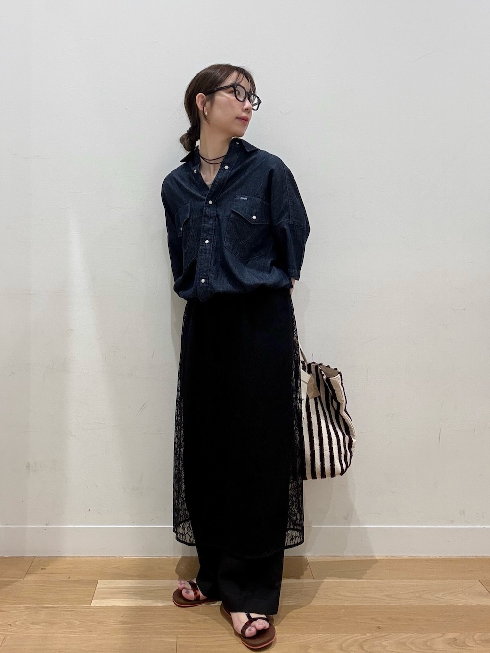ブルー系のシャツ/ブラウス、ブラウン系のトートバッグ、ブラック系のその他パンツを着用したレディースの春コーディネートの2枚目の写真