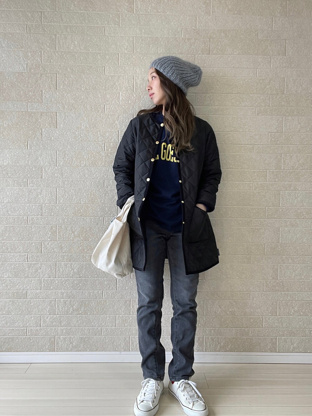 グレー系のデニムパンツ、ブラック系のその他アウター、ホワイト系のスニーカーを着用したレディースの冬コーディネートの2枚目の写真